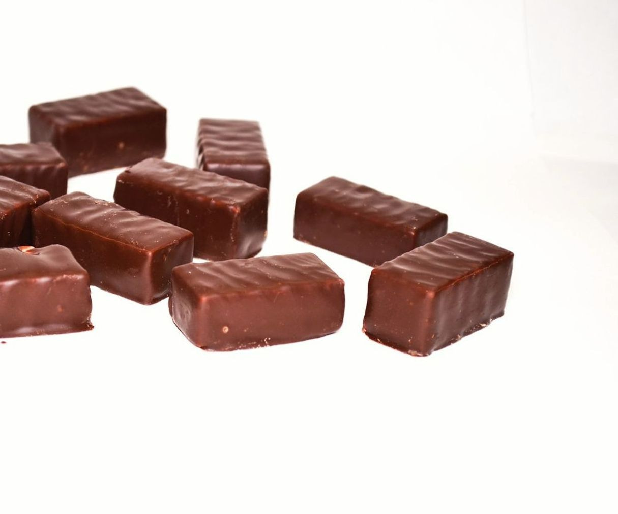 Manos preparando bombones de chocolate en la mesa de trabajo